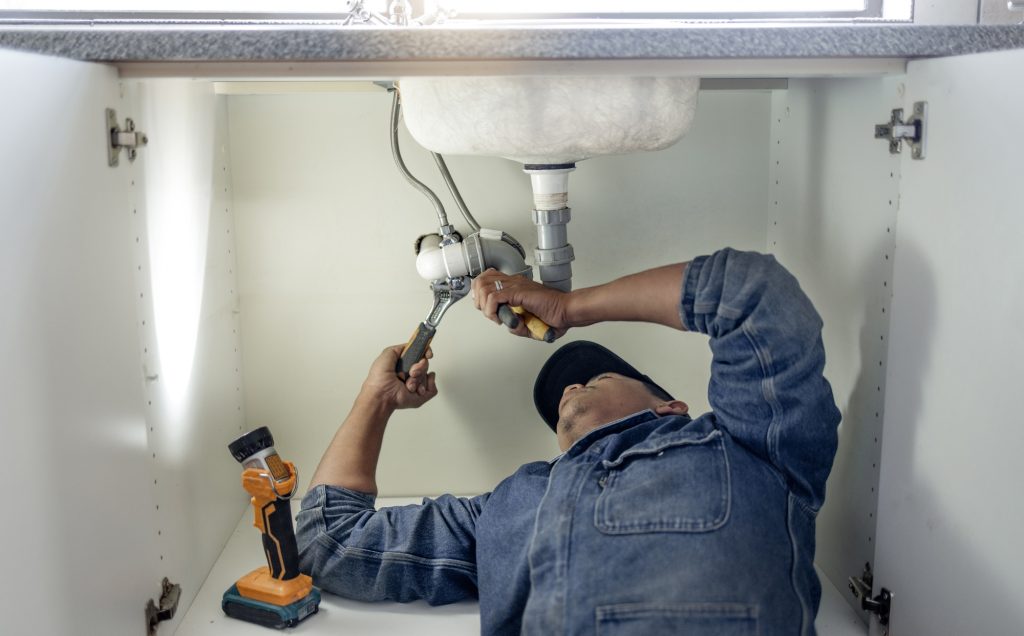 Plumber, man and handyman with plumbing, home renovation and manual labour with tools. Construction